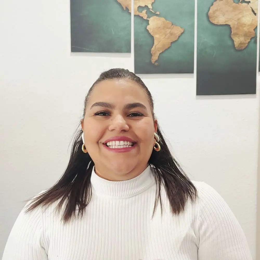 Devora sonriendo en el mostrador de la agencia